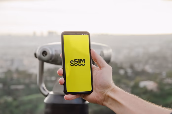 a person holding up cell phone with logo esim
