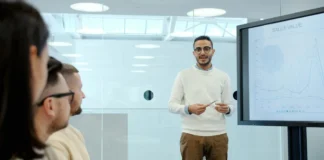 Leaders Use Employee Recognition Technology to Keep the Startup Vibe man standing in front of screen
