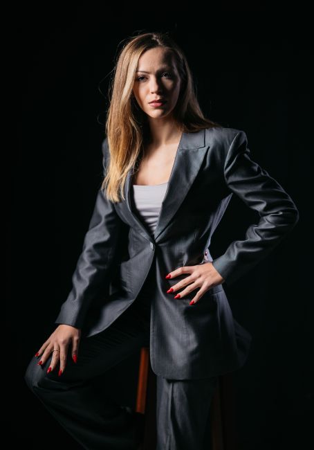 Jana Radojcic standing in a business suite with her hand on her hip