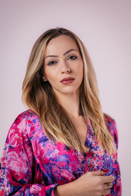 Jana Radojcic looking into the camera with a bright, beautiful dress