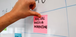 The Biggest Reasons Social Media Ad Campaigns Fail a hand is writing on sticky note
