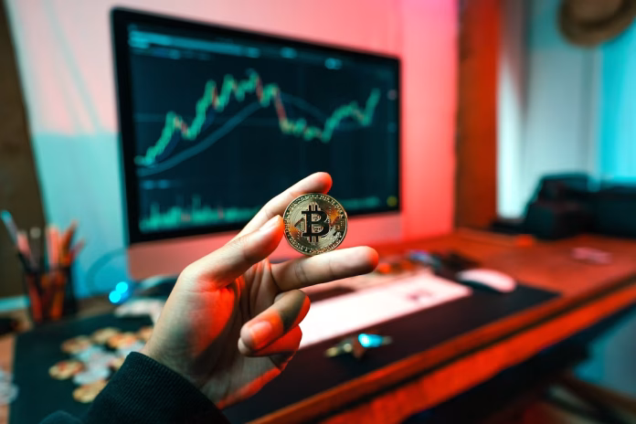 a person holding coin in front of computer
