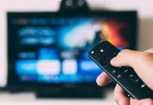 How Smart TV Technology Is Changing Commercial DIRECTV Installations a person holding remote