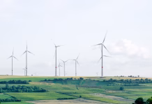 Beyond Waste Containment: How AI, IoT, and Geosynthetics Are Driving Smarter, Cost-Efficient Landfill Expansion windmill surronded by grass during daytime