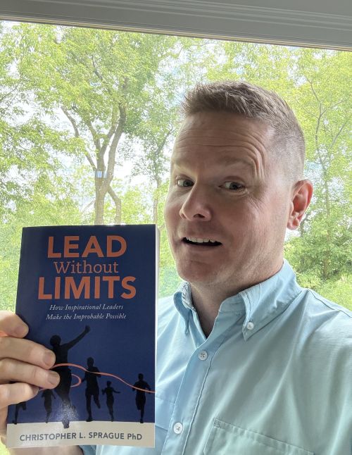 Christopher Sprague holding up his new book.